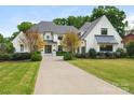 Elegant home boasts a manicured front yard, a circular driveway, and timeless architectural design at 2343 Vernon Dr, Charlotte, NC 28211