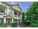 Charming townhome with two stories, front porch, balcony, fenced yard, and neutral-colored siding at 2355 Crockett Park Pl, Charlotte, NC 28203