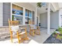 Close-up of a cozy front porch with stone accents and rocking chairs at 3153 Pinehills Way, Mount Holly, NC 28120
