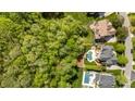 Stunning aerial view of a property with a pool, patio, lush greenery, and bordering woods at 3306 Delamere Dr, Matthews, NC 28104