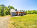 Charming blue home with a covered porch and mature trees, set on a sunny lot with green grass at 3546 Mount Pleasant N Rd, Concord, NC 28025