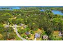 Expansive aerial view showcases the neighborhood's lush greenery and serene lake access, with homes nestled among the trees at 4160 Isle Of Pines Dr, Denver, NC 28037