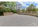 Long paved driveway to home, bordered by attractive beige brick and masonry privacy wall and spring trees at 455 W Gleneagles Rd, Statesville, NC 28625