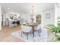 Bright dining room features modern chandelier, seating for six, and a view into the updated kitchen at 5514 Milford Rd, Charlotte, NC 28210
