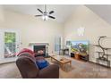 Inviting living room featuring a fireplace, vaulted ceiling, ceiling fan, and natural light at 6053 Treetop Ct, Charlotte, NC 28212