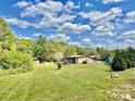Expansive backyard with lush green grass, outbuildings, and mature trees, perfect for outdoor enjoyment at 6401 Alley Rd, Catawba, NC 28609