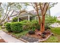 Charming cottage with lush landscaping, brick retaining wall and mature tree in the front yard at 6726 Park Meadows Pl, Huntersville, NC 28078