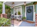 Cozy front porch with seating, decorative lanterns, and a welcoming wreath on the blue front door at 6726 Park Meadows Pl, Huntersville, NC 28078