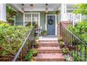 Inviting front porch with potted plants, brick stairs, and charming decor surrounding the front door at 6726 Park Meadows Pl, Huntersville, NC 28078