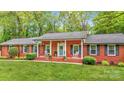 Charming brick home with a welcoming front porch and rocking chairs at 722 12Th Nw Ave, Hickory, NC 28601