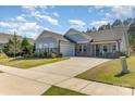 Charming single-story home featuring stone accents, a well-manicured lawn, and a two-car garage on a sunny day at 8011 Green Heron Ct, Belmont, NC 28012