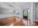 Elegant dining room featuring hardwood floors, wainscoting, decorative wallpaper, and modern lighting at 8169 Clems Branch Rd, Indian Land, SC 29707