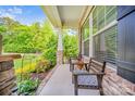 Inviting covered front porch with seating area and lush greenery, perfect for relaxing at 8169 Clems Branch Rd, Indian Land, SC 29707