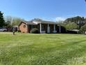 Lovely single story brick home with a vast, well-maintained green lawn and sunny sky at 901 Ridge St, Albemarle, NC 28001
