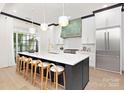 Modern kitchen boasts a large island with barstool seating, stainless appliances, and a custom vent hood at 9020 Tynecastle Commons Ct, Charlotte, NC 28226
