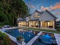 Luxury backyard with a large pool, covered patio, outdoor kitchen, and lush landscaping at 100 Verbena Ct, Weddington, NC 28173