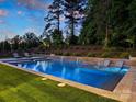Beautifully designed pool area with multiple waterfall features, in-pool seating, and lush green surroundings at 100 Verbena Ct, Weddington, NC 28173