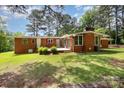A spacious backyard featuring a brick house, wooden deck, and lush green lawn at 1012 Hawkinstown Rd, Salisbury, NC 28144