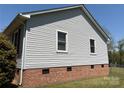 Close-up on the house exterior featuring horizontal vinyl siding over a classic brick foundation at 107 Plumtree Dr, Kings Mountain, NC 28086