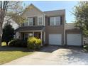 Inviting two-story home with a two car garage, complemented by mature landscaping and a welcoming porch at 1104 Valley St, Statesville, NC 28677