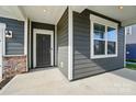 Front porch featuring sleek design elements and a gray color scheme with white trim accents at 117 Rooster Tail Ln, Troutman, NC 28166