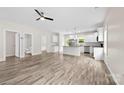 Open-concept living room featuring wood-look floors, ceiling fan, and modern lighting at 1301 Marble St, Charlotte, NC 28208