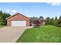Well-maintained brick home with attached garage, landscaped front yard, and inviting entrance at 131 Fieldhaven Pl, Troutman, NC 28166