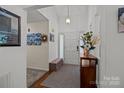 Bright entryway features neutral carpet, wood flooring, bench, and an overhead hanging light at 16070 Palawan Ct, Tega Cay, SC 29708