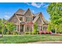 Charming exterior with stone and brick, complemented by manicured landscaping and a well-maintained lawn at 17909 Golden Meadow Ct, Davidson, NC 28036