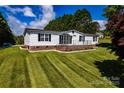 Charming single-story home with well-manicured front lawn and a covered front porch with black railings at 186 Ellendale Ln, Taylorsville, NC 28681