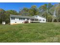 Exterior of home, featuring a well-maintained lawn, with a wooden porch and natural landscaping at 1869 Wooten St, Catawba, NC 28673