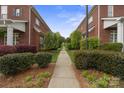 A picturesque pathway lined with lush greenery and manicured hedges between two brick homes at 20217 Middletown Rd, Cornelius, NC 28031