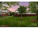 Beautiful landscaped backyard with a brick fence surrounding lush greenery. *Virtually Staged* at 20217 Middletown Rd, Cornelius, NC 28031
