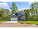 Charming two-story home with blue siding, an attached two-car garage and a well-manicured lawn at 2668 Polo Ln, Maiden, NC 28650