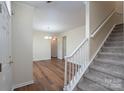 Inviting entryway with wood floors, a staircase, and neutral paint, creating a warm and welcoming ambiance at 2684 Sunberry Nw Ln, Concord, NC 28027