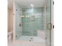 Modern bathroom featuring a glass shower with green tiling, gold hardware, and shower bench at 2717 Springway Dr, Charlotte, NC 28205