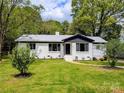 Ranch-style home with freshly cut green grass and a landscaped garden at 2717 Springway Dr, Charlotte, NC 28205