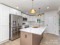 Modern kitchen features white cabinets, stainless steel appliances, and a stylish island with a sink at 2717 Springway Dr, Charlotte, NC 28205