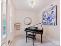 Bright music room featuring a piano, modern decor, and large window with natural light at 3064 Selwyn Ave, Charlotte, NC 28209