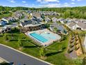 Aerial view showcasing a community pool, clubhouse, playground, and manicured green spaces in a residential neighborhood at 3129 Burnello Ct, Iron Station, NC 28080