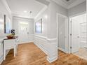 Inviting hallway with hardwood floors, white trim, and a view of the front door at 3129 Burnello Ct, Iron Station, NC 28080
