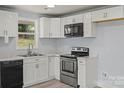 Modern kitchen with white cabinets, stainless steel appliances, and light countertops, offering a sleek and functional space at 313 Villa St, Kannapolis, NC 28083