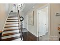 Open hallway features a staircase with dark wood treads, hardwood floors, and white trim at 3216 Moss Ln, Charlotte, NC 28206