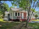 Cozy home with red brick and gray siding, featuring a welcoming front porch at 3824 Freedom Dr, Charlotte, NC 28208