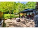 Cozy backyard patio with pavers, gazebo, fire pit, and outdoor seating, ideal for entertaining guests at 4224 Firwood Ln, Charlotte, NC 28209