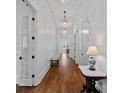 Long hallway with hardwood floors, elegant lighting fixtures, and white trim at 503 Walnut St, Davidson, NC 28036