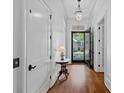 Hallway with hardwood floors, an open door and white trim at 503 Walnut St, Davidson, NC 28036