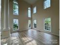 Spacious living room with soaring ceilings, large windows, and hardwood flooring at 6316 Glengarrie Ln, Huntersville, NC 28078