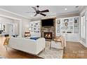 Living room with cozy fireplace, built-in shelving, ceiling fan and large comfortable sofas at 7181 Windy Ridge Dr, Iron Station, NC 28080