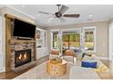 A cozy living room with stone fireplace that opens to the outdoor pool area at 7181 Windy Ridge Dr, Iron Station, NC 28080